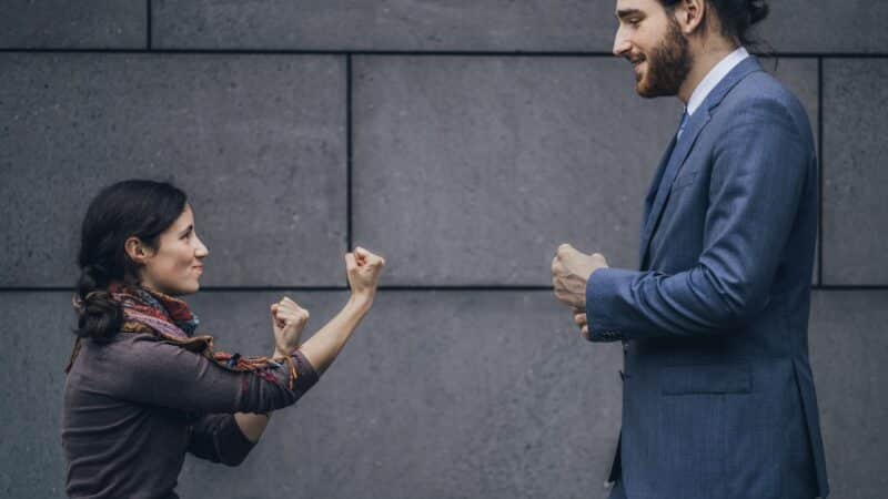 Businessman and woman fighting Durchsetzungsvermögen kann auch Spaß machen.